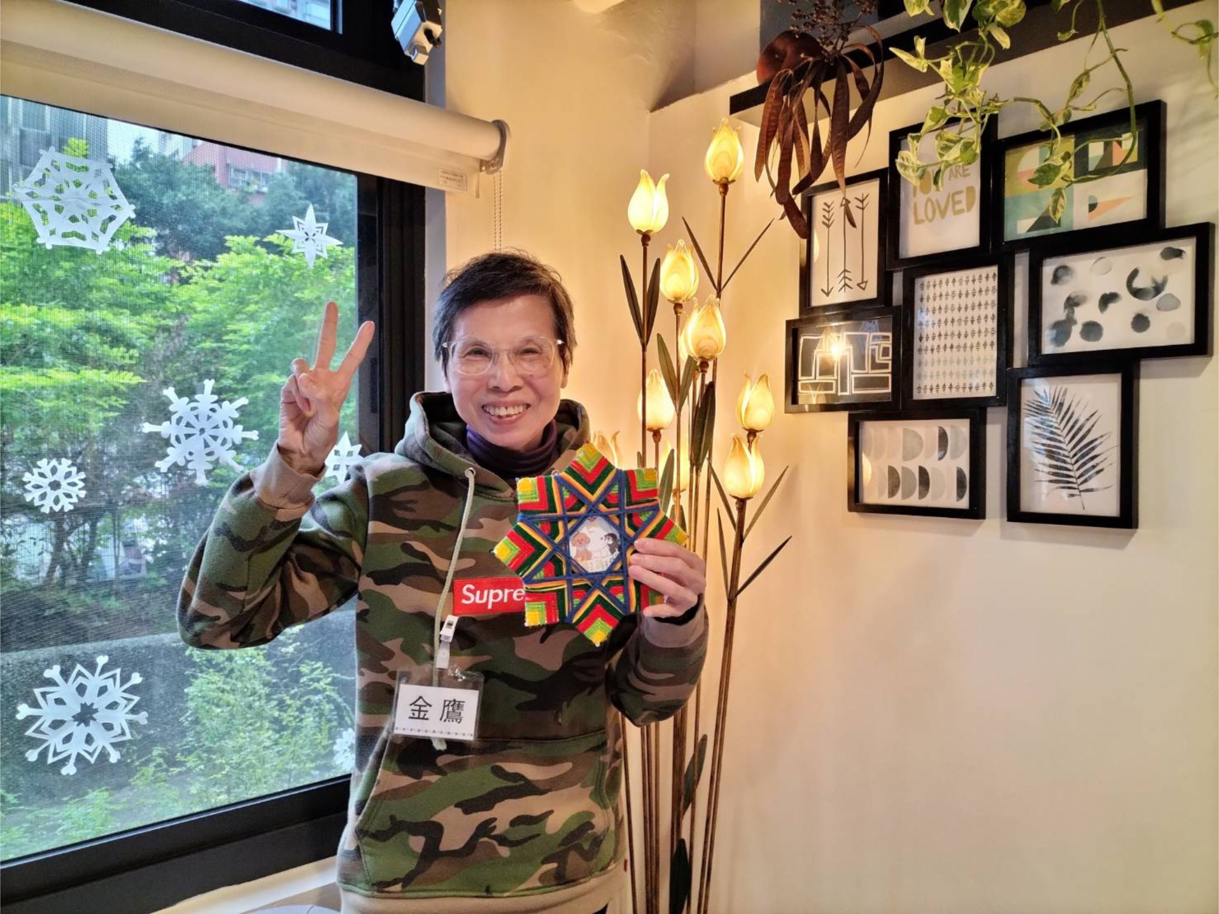 許金鷹拿著手作的彩色編織星星，對著鏡頭自信比著YA