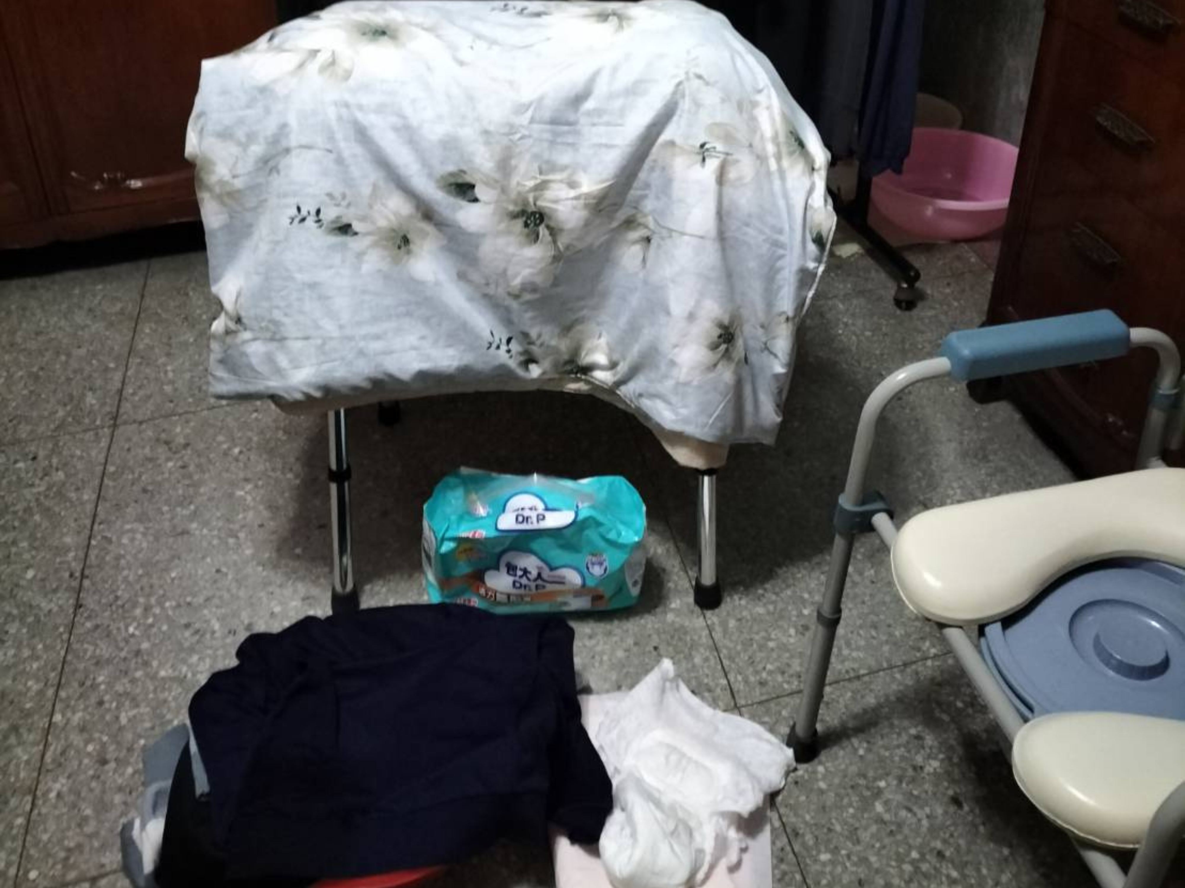 長照現場散落的成人紙尿褲與便盆椅